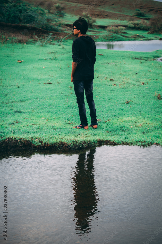 Naklejka premium Reflection of man in water of the lake