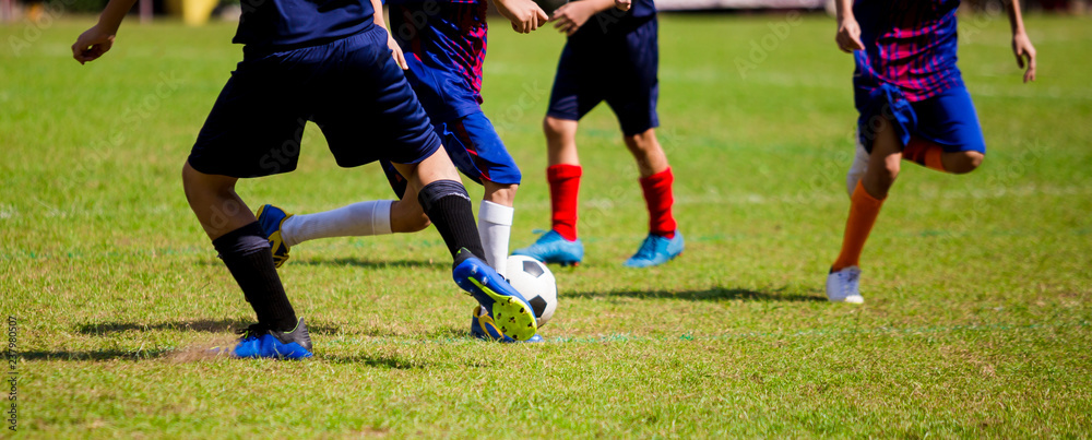 Kid soccer players run to trap and control the ball for shoot to goal Kid soccer players run to trap and control the ball for shoot to goal