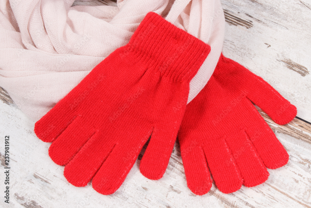 Red womanly gloves with shawl for autumn or winter on old rustic board Red womanly gloves with shawl for autumn or winter on old rustic board