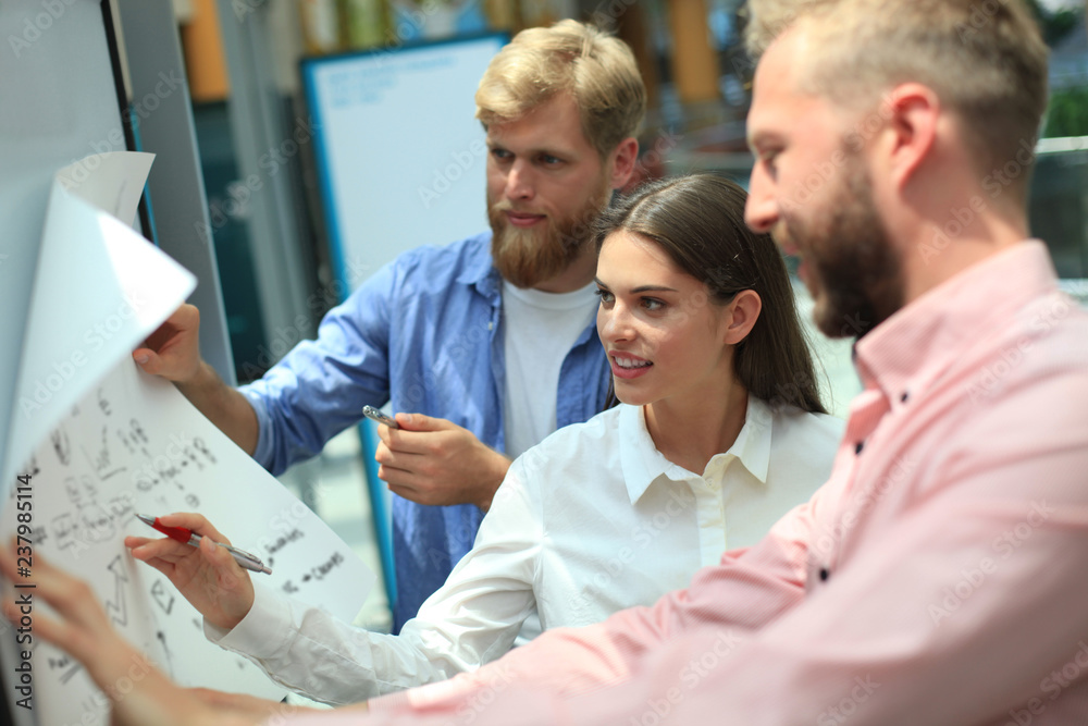 Group of young business people and designers in smart casual wear. They working on new project. Group of young business people and designers in smart casual wear. They working on new project.