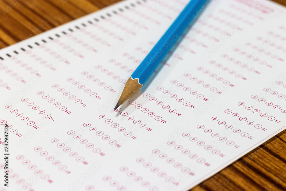 Blue pencil on paper computer sheet. Standardized test form with answers bubble. Multiple choice answer sheets. Ideas about education. Blue pencil on paper computer sheet. Standardized test form with answers bubble. Multiple choice answer sheets. Ideas about education.
