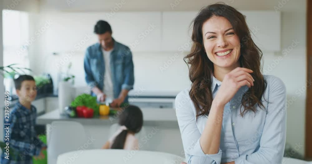 Portrait of a smiling beautiful middle aged woman in living room in slow motion on the background of family time at home. Portrait of a smiling beautiful middle aged woman in living room in slow motion on the background of family time at home.