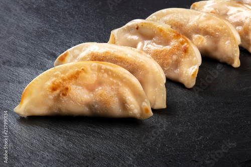 A closeup photo of gyozas, Asian dumplings, pn a black background with a place for text