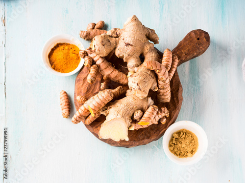 Turmeric and ginger in powder and roots on board
