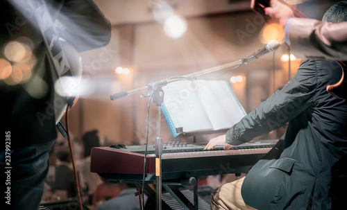 Shot of a man playing piano on stage in live concert of electronic music