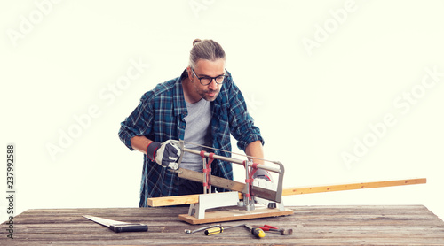 worker in blue shirt sawing wood