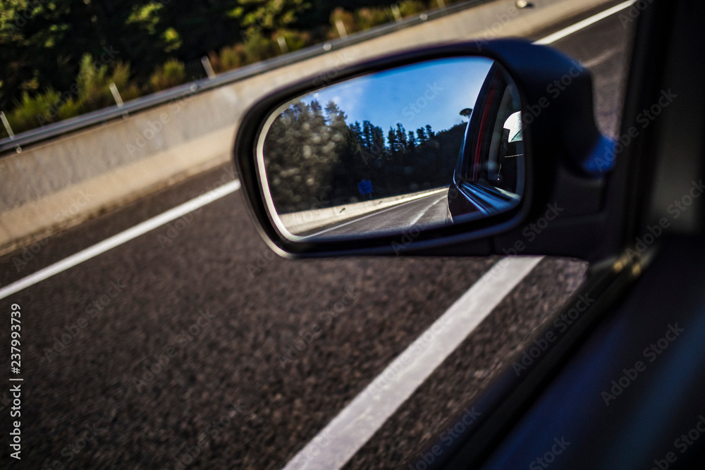 Left mirror car reflection on a highway