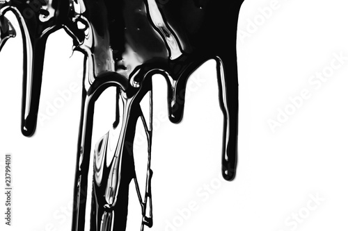 Flows of black glossy paint close-up on white background