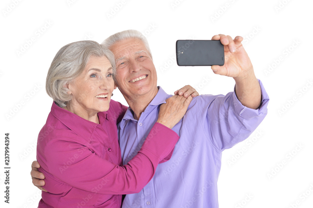 Portrait of a happy senior couple taking selfie photo on white background