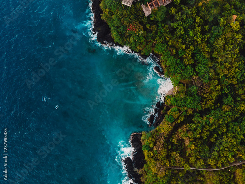Blue ocean in tropics with rocky coastline. Aerial view.