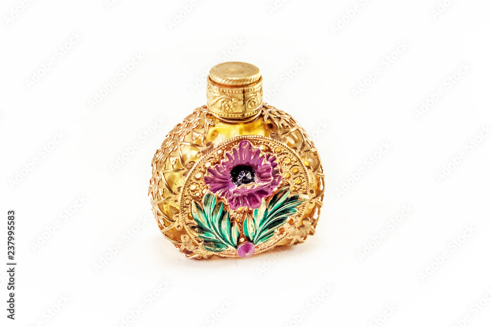 Vintage perfume bottle in gold filigree isolated on white background
