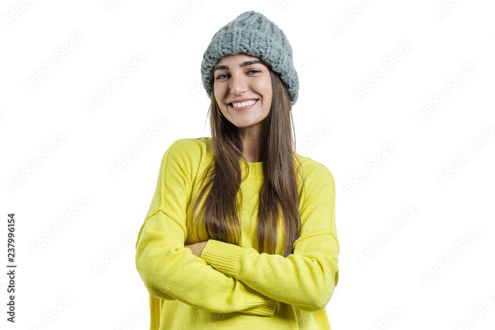 Young beautiful woman in yellow sweater and gray big loop knitted beanie hat, hands folded, looking at the camera on white isolated background Young beautiful woman in yellow sweater and gray big loop knitted beanie hat, hands folded, looking at the camera on white isolated background