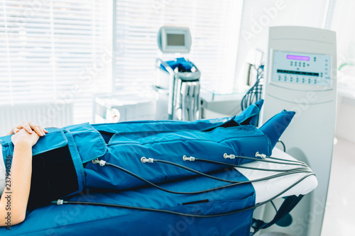 Tableau sur toile Cropped view of woman lying in massaging suit at the spa clinic for the treatment of pressure therapy procedure