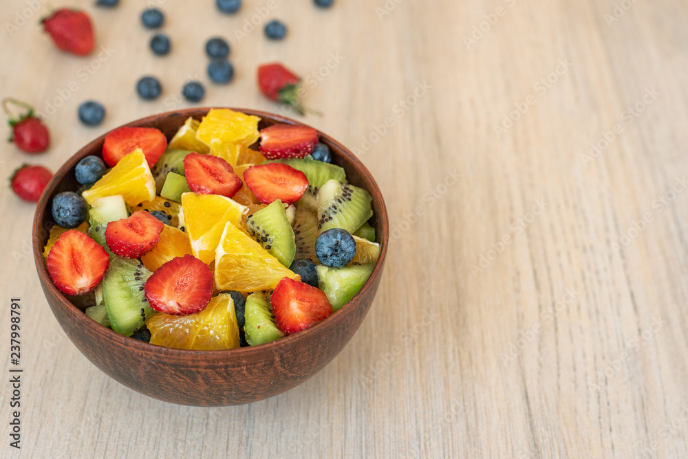 Healthy fresh fruit salad in bowl on light background. With copy space Healthy fresh fruit salad in bowl on light background. With copy space