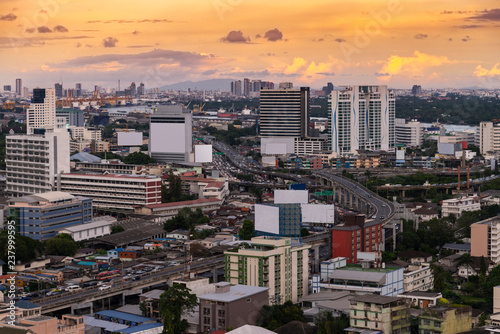 Aerial view of Bangkok city skyline and express way in golden yellow light sunset sky