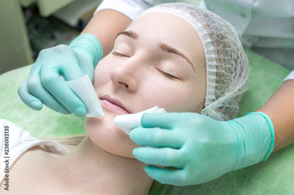 Naklejka premium Facial cleansing by a beautician in a beauty salon