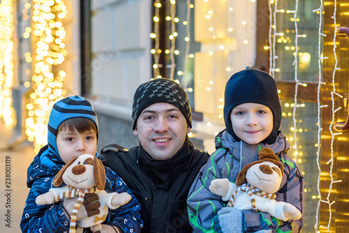 family, childhood, season and people concept - happy in winter clothes over snowy city background photo