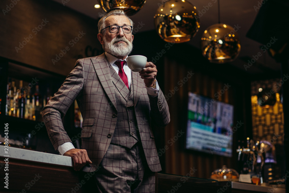 Portrait of wealthy prosperious senior businessman in drinking coffee near bar counter at elite gentlemen club Portrait of wealthy prosperious senior businessman in drinking coffee near bar counter at elite gentlemen club