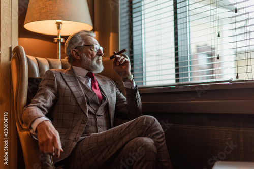 Photos Serious old-aged businessman wearing classy custom tailored suit, red tie and ex