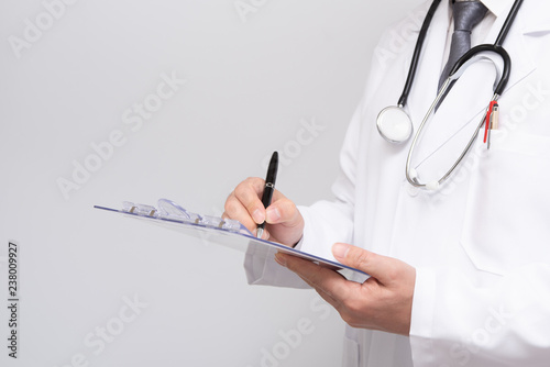 Close up of doctor s hands writing on medical chart.