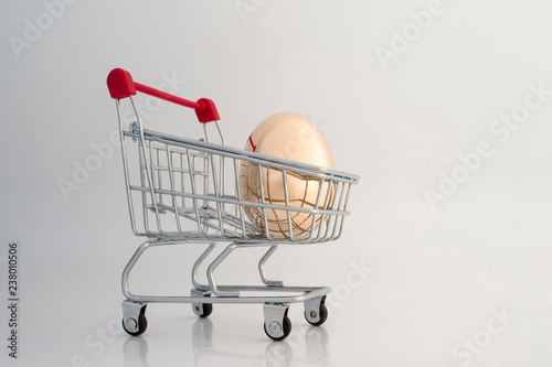 A Golden egg made of metal in a supermarket grocery cart. The concept of a unique offer for the client.
