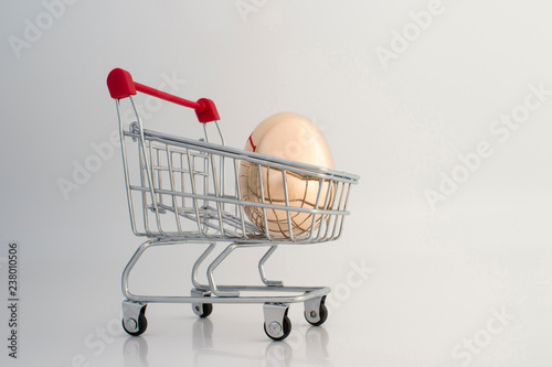 A Golden egg made of metal in a supermarket grocery cart. The concept of a unique offer for the client. photo