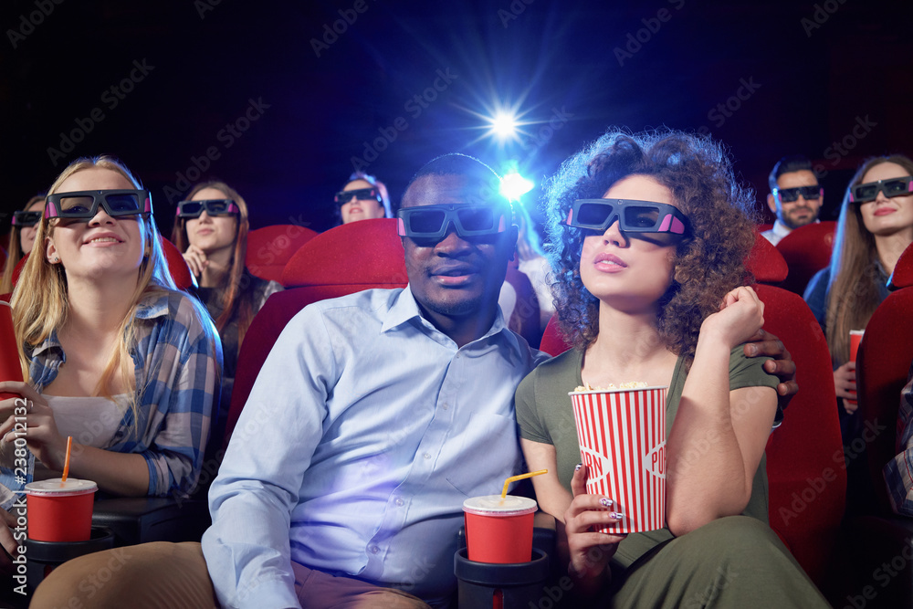 Cheerful couple having date in cinema.