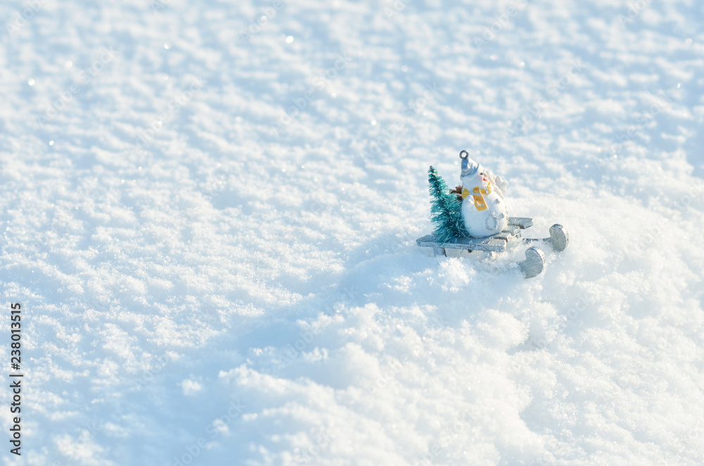  snowman in a sleigh with a Christmas tree in snowdrifts. Winter season background.
