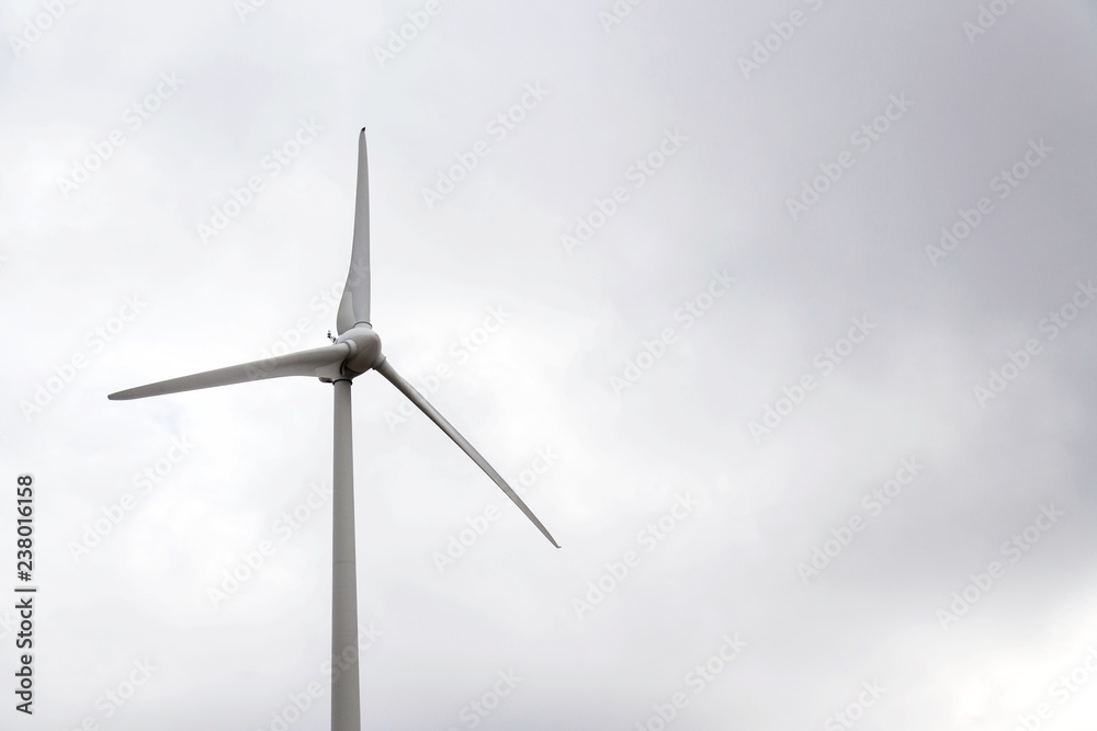 White wind turbine power station, foggy day, copy space on cloudy sky, sustainable renewable electricity concept White wind turbine power station, foggy day, copy space on cloudy sky, sustainable renewable electricity concept