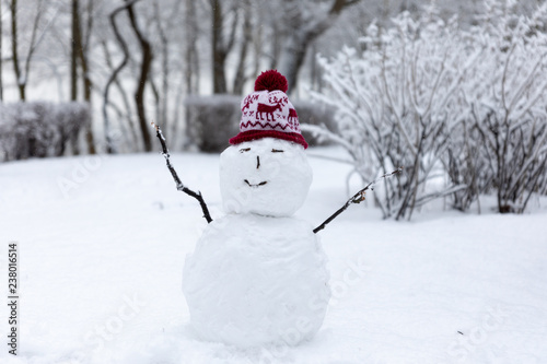Winter mood: Small simplistict snowman in Christmas hat © oleksandr.info