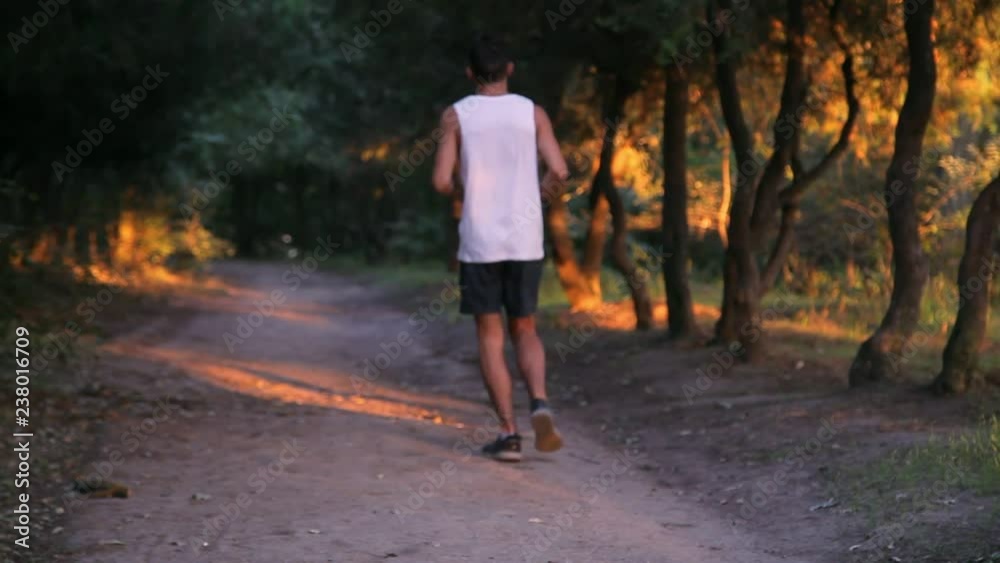 young boy running at sunset in the park young boy running at sunset in the park