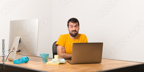 Man working with laptot in a office with confuse face expression while bites lip photo