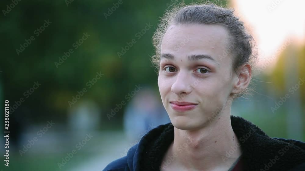 funny young boy with tied hair on the street funny young boy with tied hair on the street