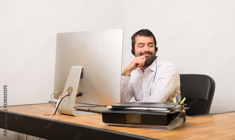 Telemarketer man in a office looking down with the hand on the chin Telemarketer man in a office looking down with the hand on the chin
