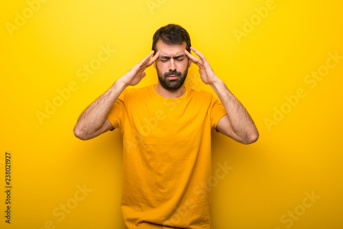 Man on isolated vibrant yellow color unhappy and frustrated with something © luismolinero