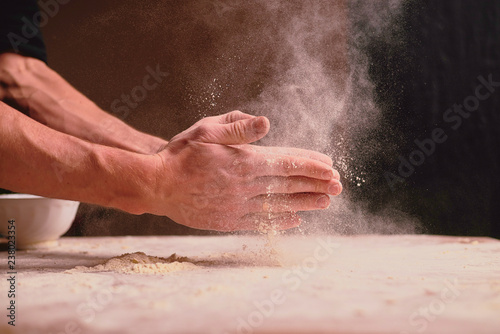 hands kneading dough on wooden table