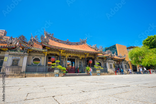 People walking in front of the gate of Longshan Temple in Taipei, Taiwan photo