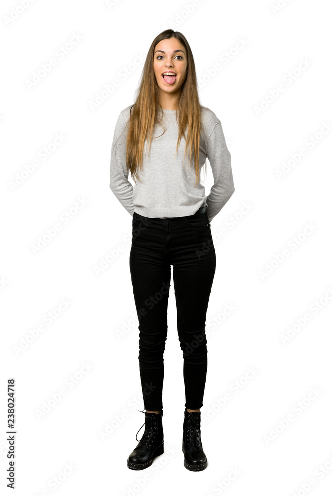 Full-length shot of young girl showing tongue at the camera having funny look on isolated white background Full-length shot of young girl showing tongue at the camera having funny look on isolated white background