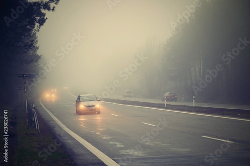 Bad weather driving - foggy hazy country road. Motorway - road traffic. Winter time.