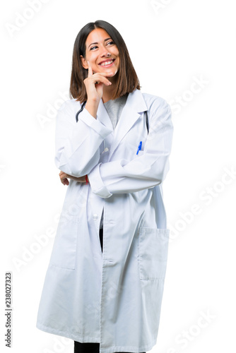 Doctor woman with stethoscope standing and thinking an idea on isolated white background