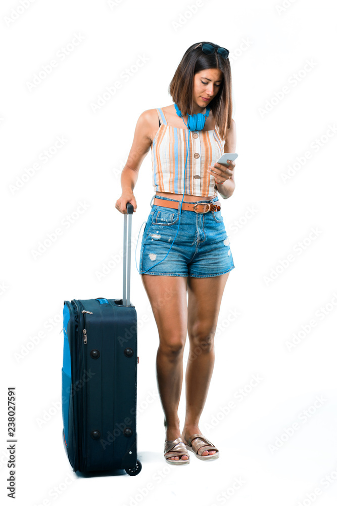 Φωτογραφία Full body of Girl traveling with her suitcase sending a message or email with th
