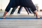 ?oncept yoga. A group of sport people doing yoga exercises outdoor. Close up of yogi male feet, Healthy lifestyle concept