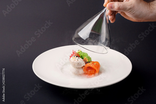 Molecular cuisine gravlax trout with garlic ice cream on a black background