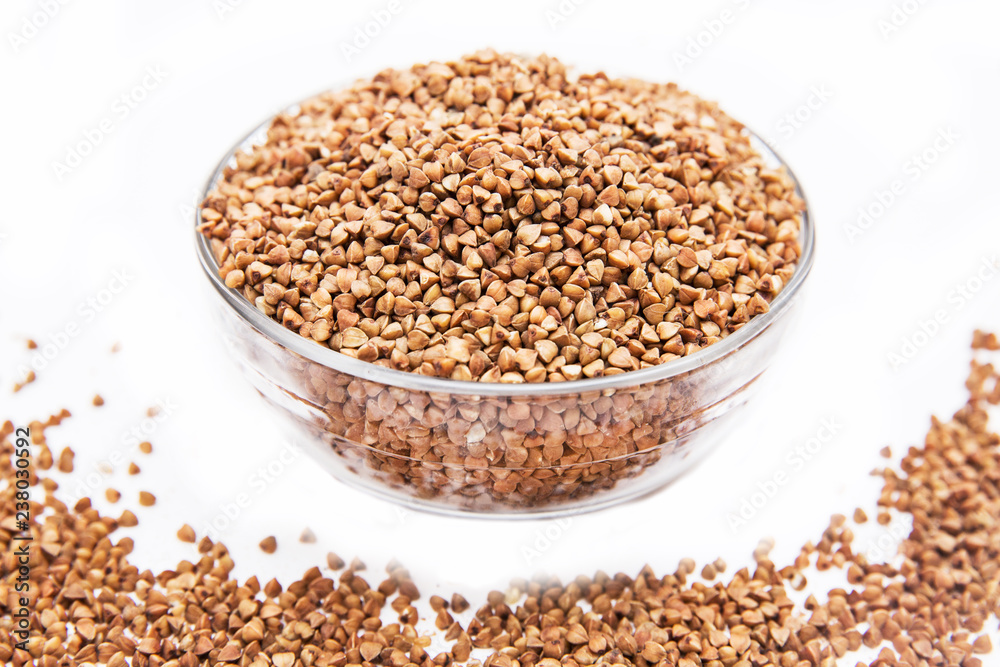 Buckwheat grain in glass bowl on white background. Isolated on white Buckwheat grain in glass bowl on white background. Isolated on white
