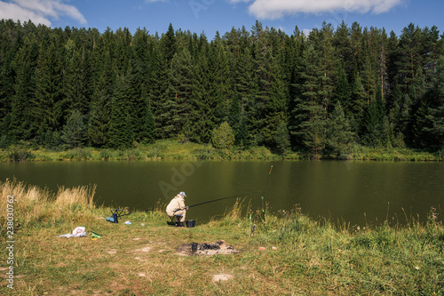 Russian fisherman fishes by lake