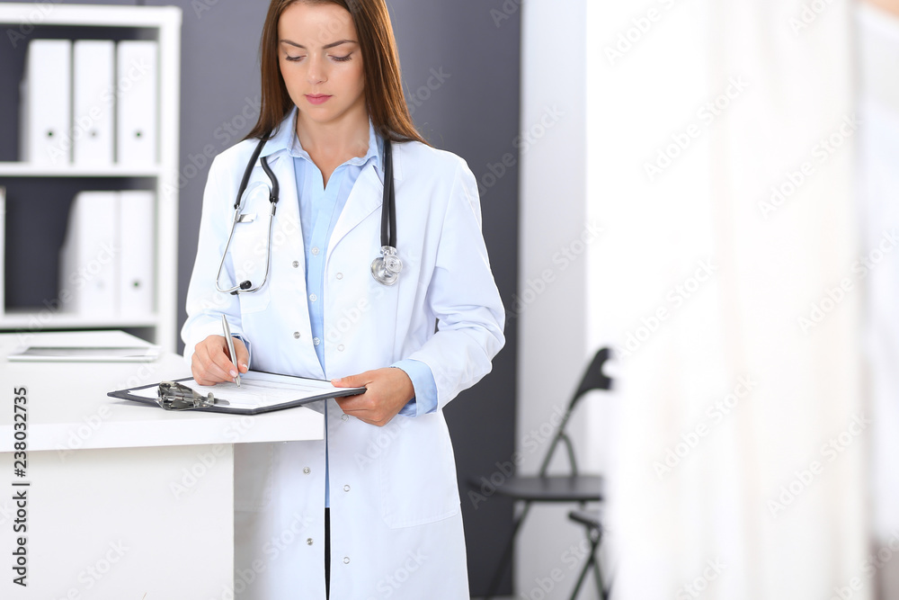 Doctor and patient discussing something while standing near reception desk in emergency hospital. Physician at work in clinic. Medicine and health care concept Doctor and patient discussing something while standing near reception desk in emergency hospital. Physician at work in clinic. Medicine and health care concept