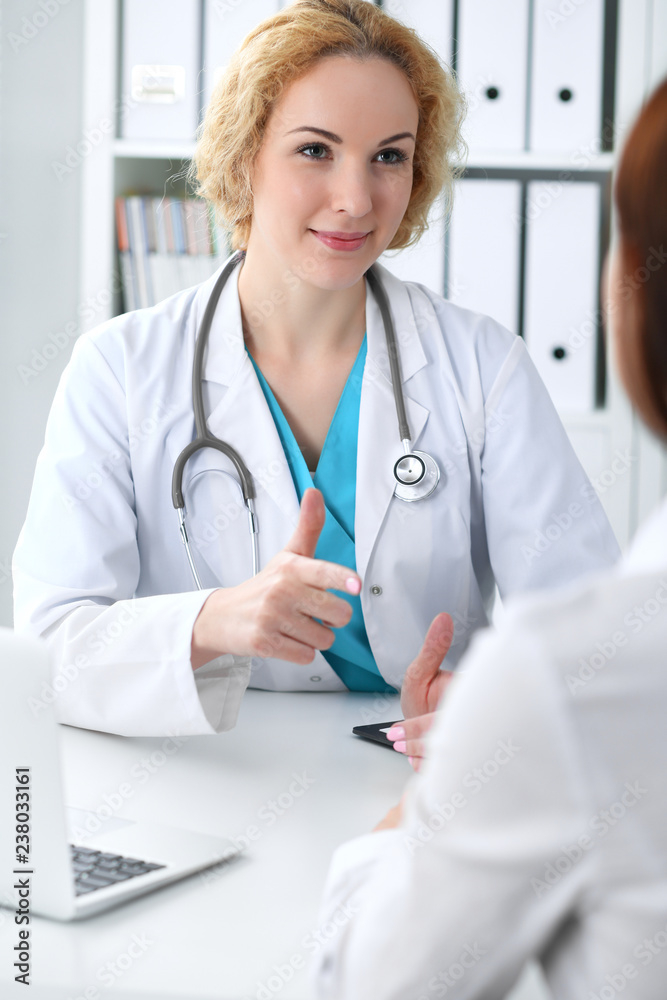 Happy blonde female doctor and patient discussing medical examination results. Medicine, healthcare and help concept Happy blonde female doctor and patient discussing medical examination results. Medicine, healthcare and help concept