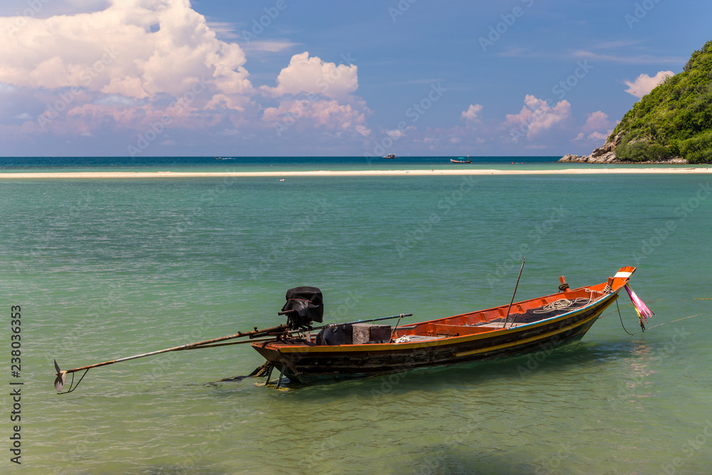 Fototapeta premium Traditional thai long boat moored at a beach