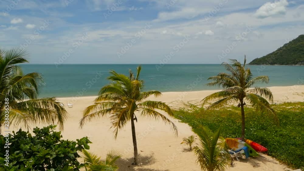 Tropical Paradise exotic white sand beach washed by blue calm sea. Sandy shore with green coconut palms under cloudy sky. idyllic landscape. holiday concept. Khanom, near Koh Samui Tropical Paradise exotic white sand beach washed by blue calm sea. Sandy shore with green coconut palms under cloudy sky. idyllic landscape. holiday concept. Khanom, near Koh Samui