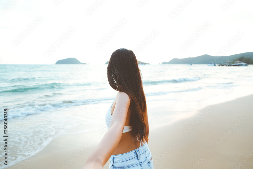 Couple holding hands on beach in sunset Couple holding hands on beach in sunset